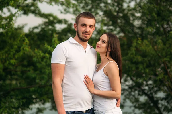 Citas en el parque. Pareja de amor de pie juntos en la hierba cerca del lago. Romance y amor —  Fotos de Stock