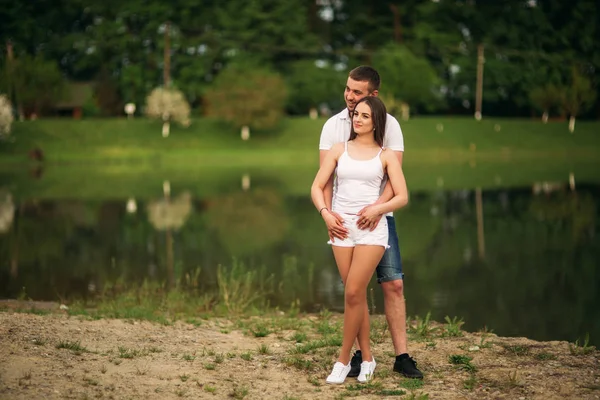 Встречаемся в парке. Любовь пара, стоящая вместе на земле рядом с озером. Романтика и любовь — стоковое фото