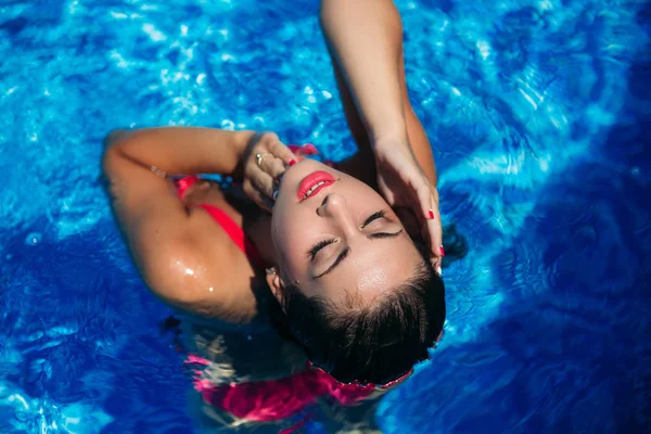 Fotosesión de moda de una chica sexy con maquillaje en un traje de baño rosa. Vista desde arriba —  Fotos de Stock