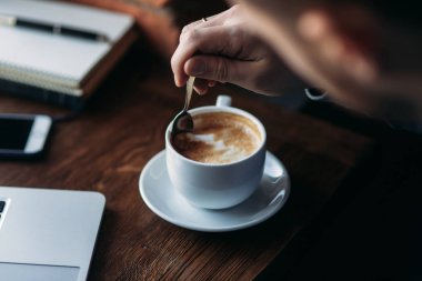 Kapuçino. Bir sakallı bir dizüstü bilgisayar bir kafede kullanır.