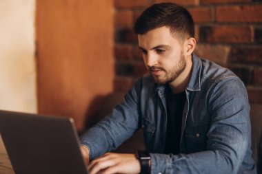 Sakallı programcı bir kafede bir dizüstü bilgisayar üzerinde çalışan