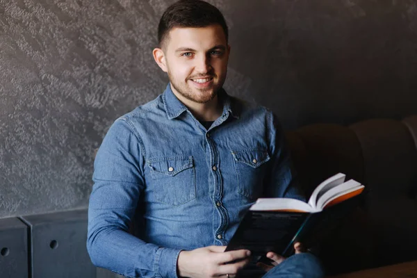 Bir kafede bir kitap okuma sakallı yakışıklı adam