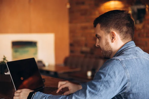 stock image Bearded programmer working on a laptop in a cafe