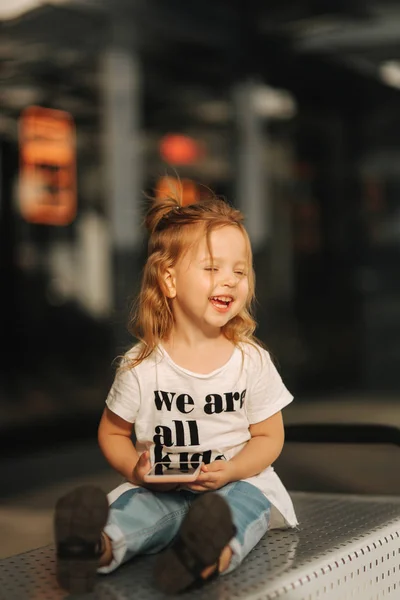 Kleines Mädchen Sitzt Auf Bänken Und Telefoniert — Stockfoto