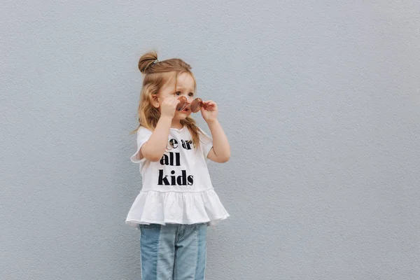 Bambina provare occhiali da sole e in posa per il fotografo — Foto Stock