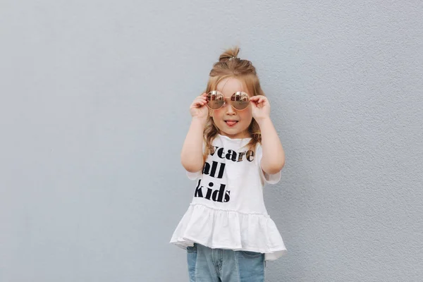Meisje proberen op zonnebrillen en poseren voor de fotograaf — Stockfoto