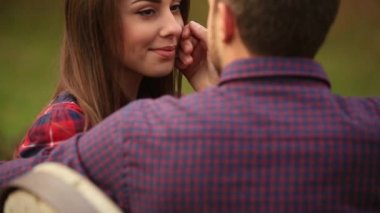 Sevgi dolu bir çift sonbaharda parkta yürüyor. Güneşli bir sonbahar gününde bir aşk hikayesi. ağır çekim