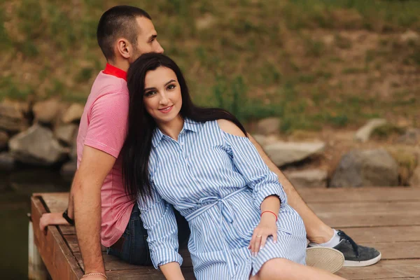 Schönes Paar spaziert im Park am See, sitzt auf der Seebrücke — Stockfoto