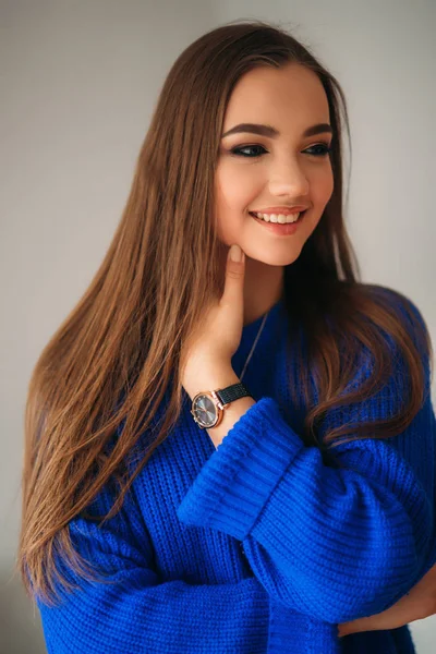 美丽的黑发女孩与一个可爱的笑容在蓝色的衬衫, 摆在一个摄影师和显示她的妆 — 图库照片
