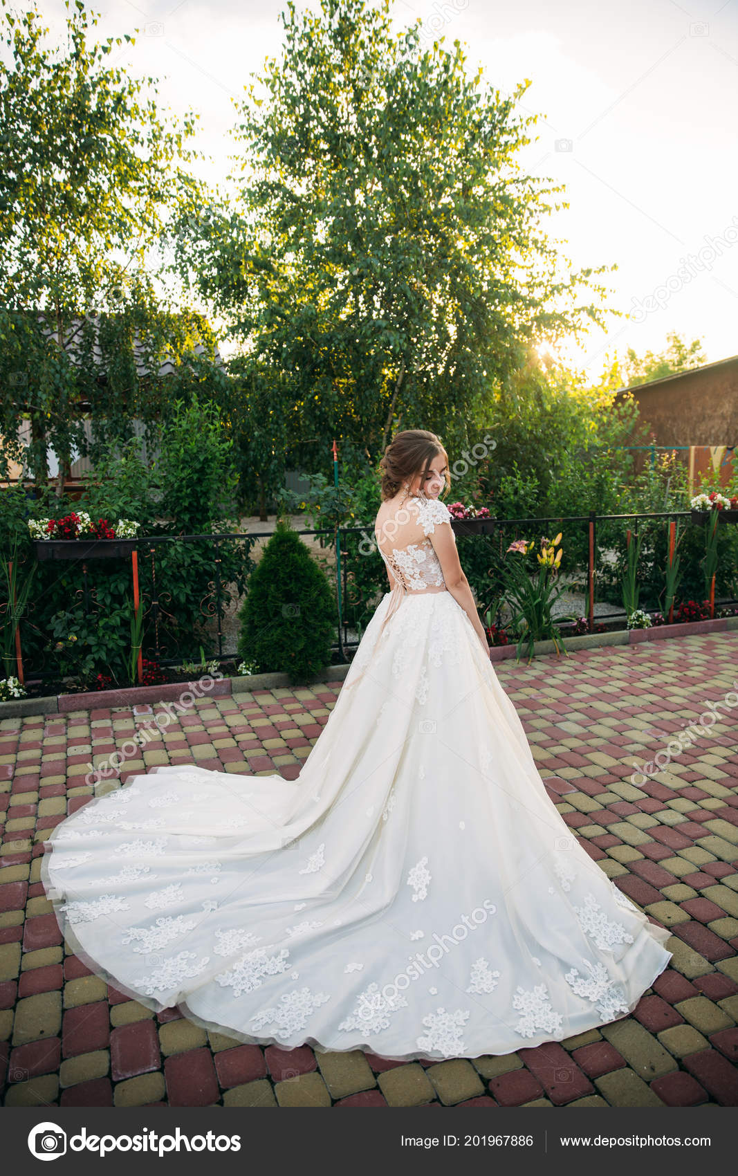 Young Girl In Wedding Dress In Park Posing For Photographer