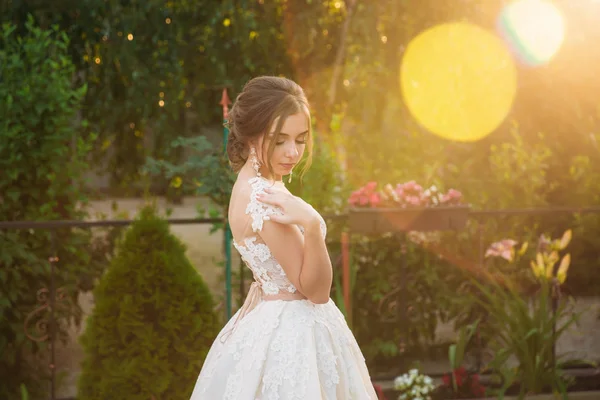 Jovem em vestido de noiva no parque posando para fotógrafo — Fotografia de Stock