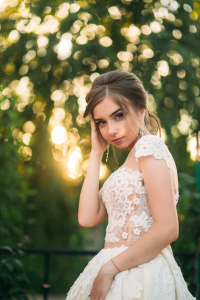 Giovane ragazza in abito da sposa in posa parco per il fotografo — Foto Stock