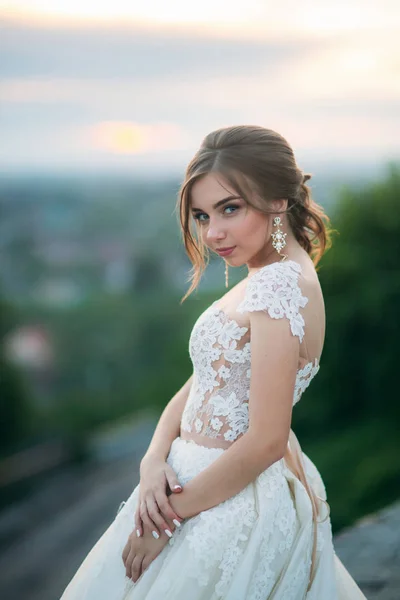 Chica adolescente en vestido de novia en la ciudad. Antecedentes ciudad puesta de sol —  Fotos de Stock