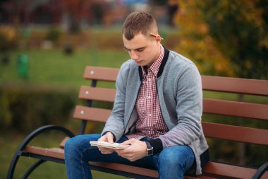 Sevimli öğrenci tezgah yazıyor onun notebool bir pensil kullanarak onun düşüncelerinde aşağı oturur