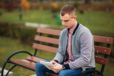 Sevimli öğrenci tezgah yazıyor onun notebool bir pensil kullanarak onun düşüncelerinde aşağı oturur