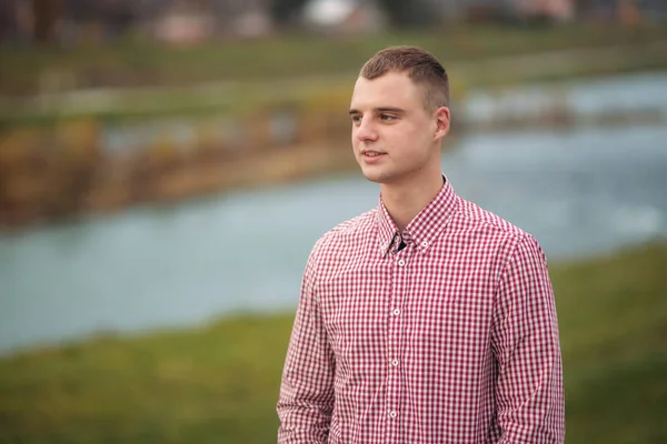 Young guy in red shirt stay in the park — Stock Photo, Image