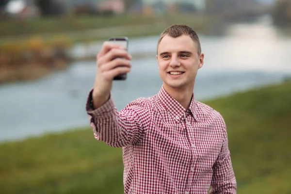 Elegante ragazzo in camicia a quadri fare un selfie — Foto Stock