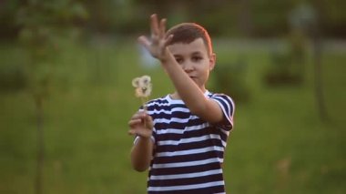 Küçük erkek ve kız çalıştırmak ve yürütmek. Karahindiba patlattılar