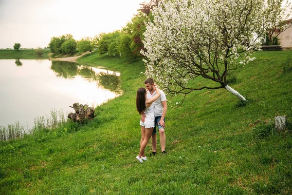 Встречаемся в парке. Любовная пара, стоящая вместе на траве у озера. Романтика и любовь — стоковое фото