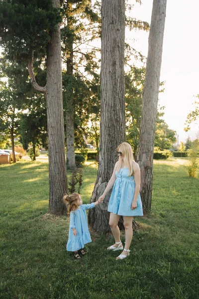 Mamma och hennes dotter promenader och hålla händerna — Stockfoto