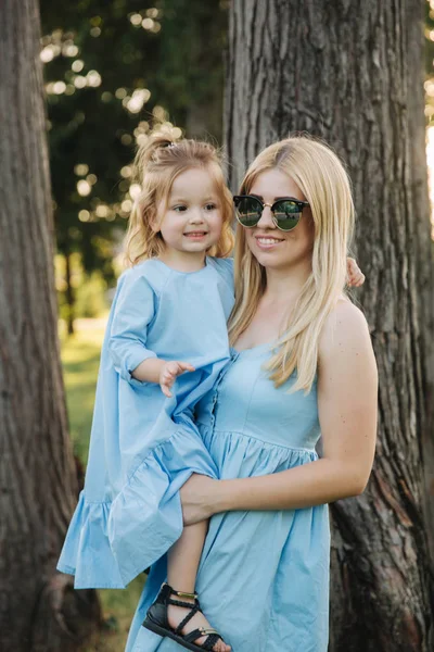 Küçük sevimli kızıyla birlikte genç güzel kadın. Genç Kızı Anne yaz parkta hugs.