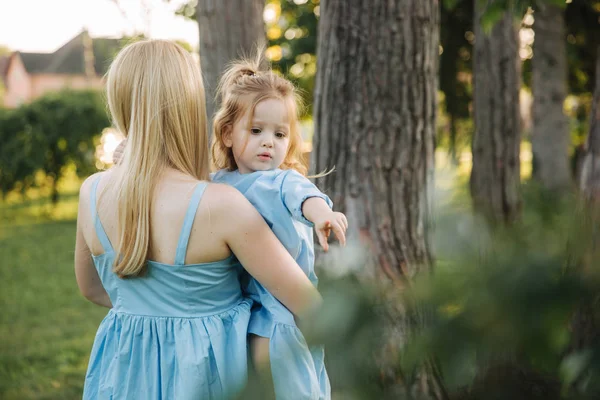 Küçük sevimli kızıyla birlikte genç güzel kadın. Genç Kızı Anne yaz parkta hugs.