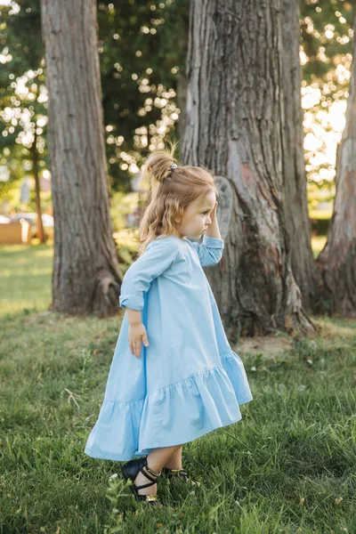 Niña en vestido azul caminar en el parque — Foto de Stock