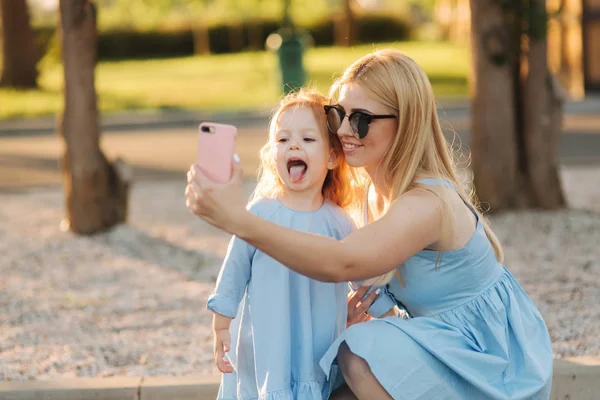 Anya és kis lánya, hogy selfie a park — Stock Fotó