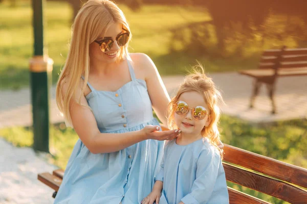 Mamma e sua figlia sono sedute su una panchina nel parco — Foto Stock