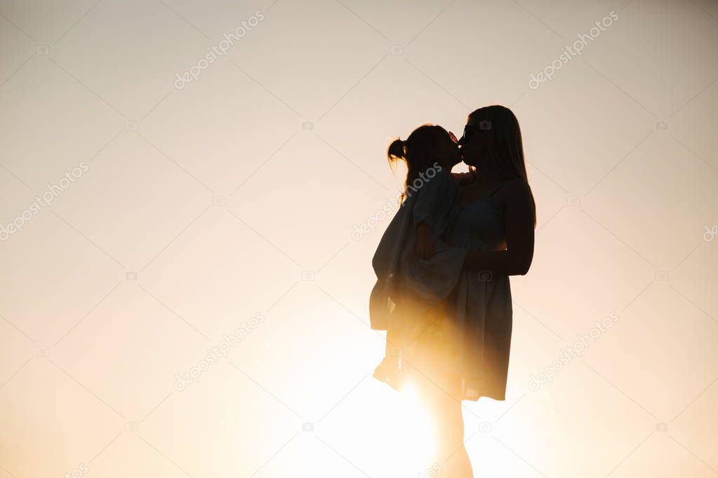 Silhouette of mother and little daughter