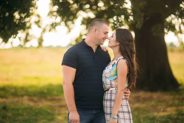 Yakışıklı ve çekici bir kız birbirlerine büyük bir yeşil ağaç öpücük. Aşk hikayesi