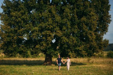 Güzel bir çift büyük bir ağaç bahçe yakınında oturan şehir dışında dinleniyor. Aşk hikayesi