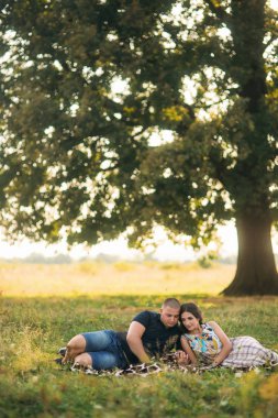 Güzel bir çift büyük bir ağaç bahçe yakınında oturan şehir dışında dinleniyor. Aşk hikayesi