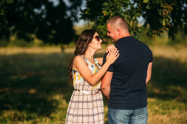 Güzel bir çift büyük bir ağaç bahçe yakınında oturan şehir dışında dinleniyor. Aşk hikayesi