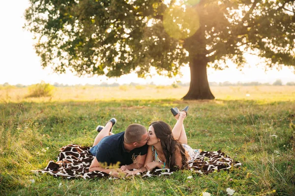 Um belo casal está descansando fora da cidade, sentado perto de uma grande árvore no jardim. História de amor — Fotografia de Stock