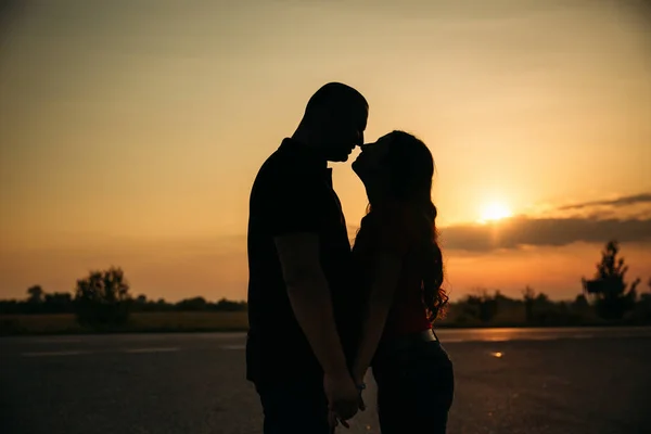 Silhouette de beau couple sur le coucher du soleil — Photo