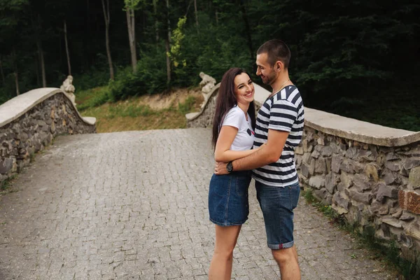 Молода пара закохалася, проводячи час разом біля великого старого мосту — стокове фото