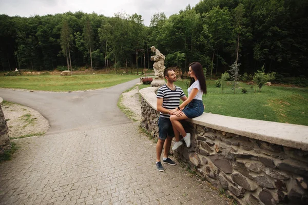 Mladý pár v lásce spolu trávili čas v blízkosti velký starý most — Stock fotografie