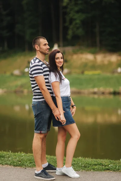 Mooie paar wandelen in het park in de buurt van het meer — Stockfoto