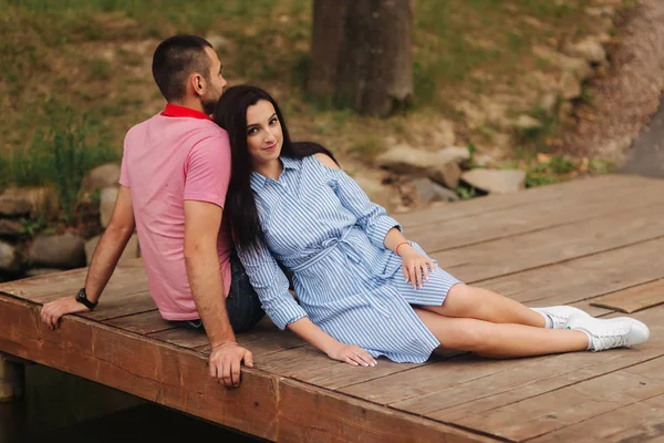 Chlap a holka si navzájem v romantické atmosféře, sedí na molu — Stock fotografie