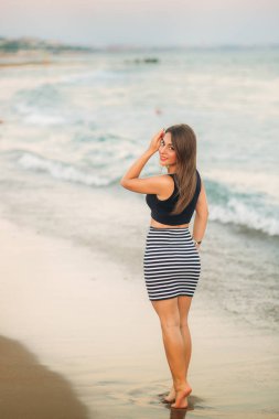 Bayan sahil boyunca yürür