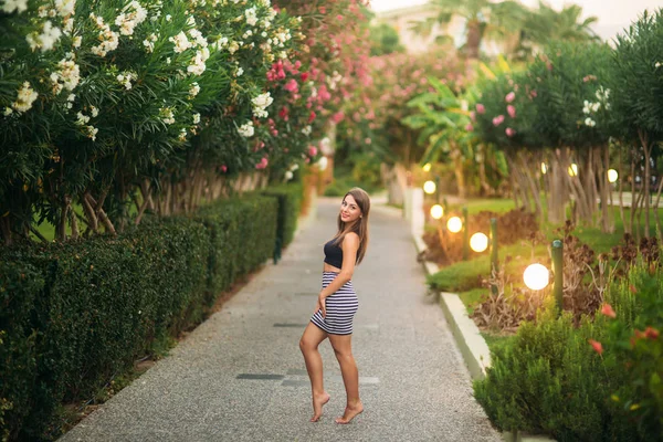 A vonzó lány mosoly. gyönyörű virágok és a fény — Stock Fotó