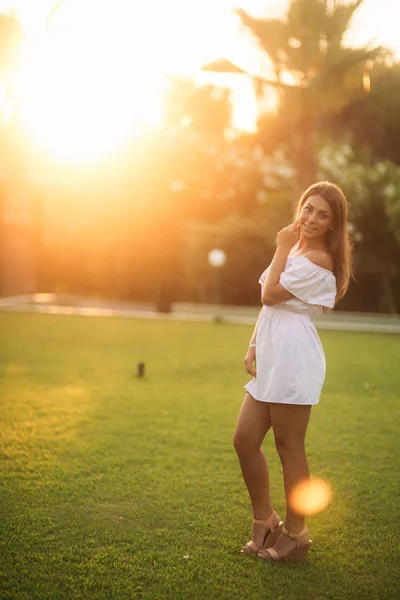 Дама в білій сукні біля долоні в літній час — стокове фото