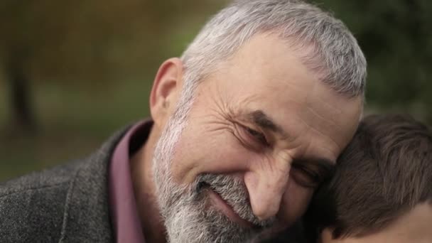 Opa und Enkel verbringen Zeit miteinander im Park. sie sitzen auf der Bank — Stockvideo