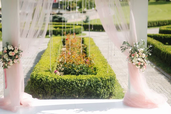 Weddind decoration on open air. Floral decor of a beautiful white arch. Beautiful beckground view of trees — Stock Photo, Image