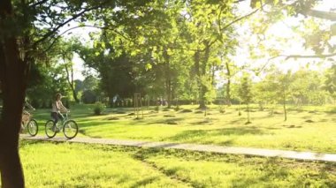 Parkta bisiklet sürme sırasında çıkan genç sevgi dolu çiftin