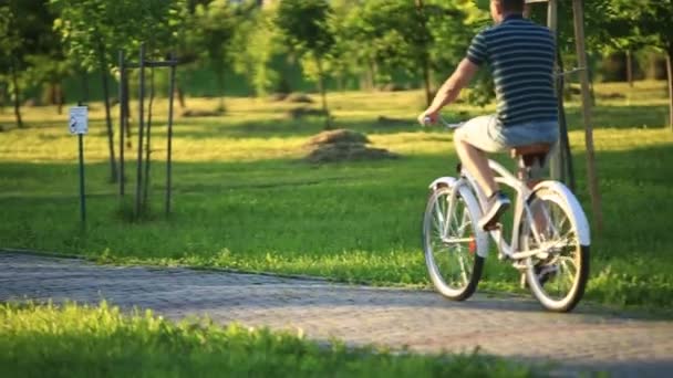 Ευτυχισμένο ζευγάρι ποδήλατο στο πάρκο. θερινή ώρα. ηλιοβασίλεμα — Αρχείο Βίντεο