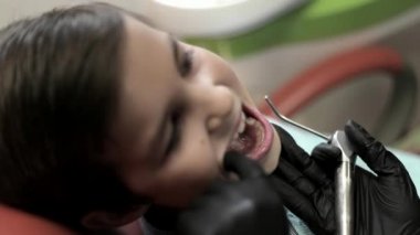 Bir çocuk diş hekimi ziyaret, bir kadın doktor Childs'ın diş davranır. yakın çekim