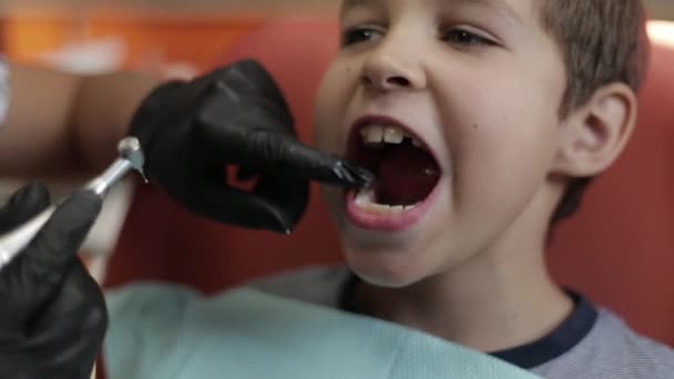 एक लड़का दंत चिकित्सक से मिलता है, एक महिला डॉक्टर बच्चों के दांतों का इलाज करता है। बंद करना — स्टॉक वीडियो