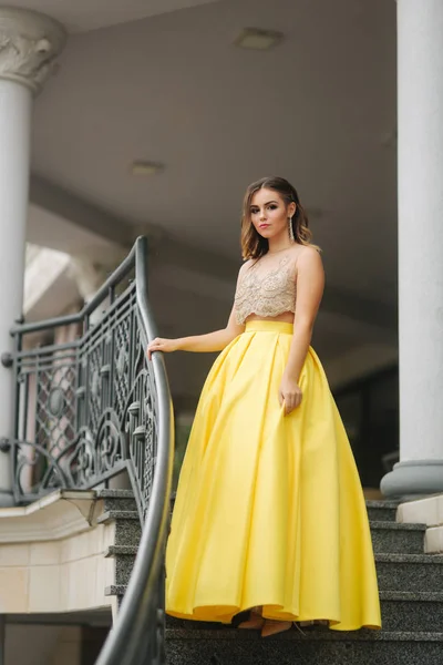 Beautiful girl with makeup and hairstyle is standing on the steps — Stock Photo, Image